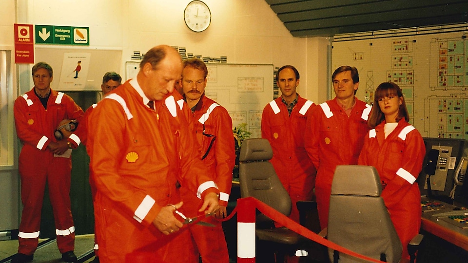 Historisk bilde: Kong Harald klipper den røde snoren i kontrollrommet på Draugen-plattformen. Shell-ansatte ser på.