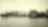 Historisk bilde i sort/hvitt: Nordnorsk fiskevær med synlig Shell tank.