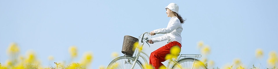 En ung kvinne sykler gjennom en sommereng