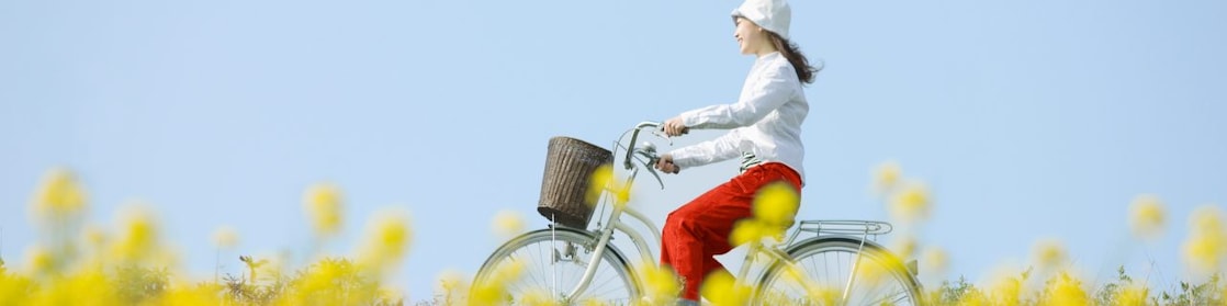 En ung kvinne sykler gjennom en sommereng