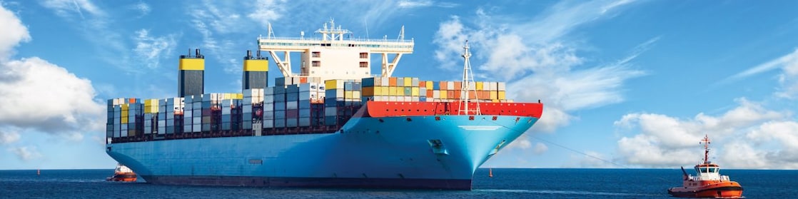 Large cargo vessel being pulled by tugboat