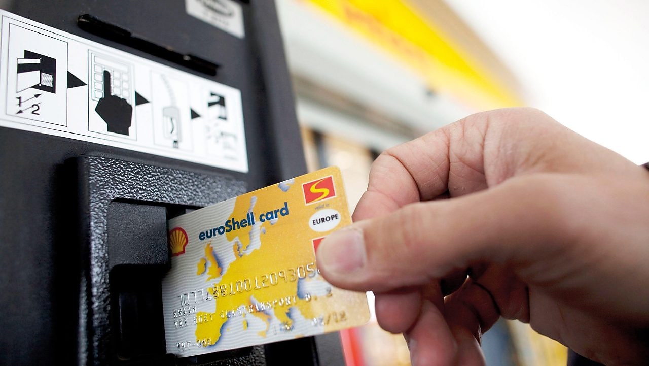 person swiping shell card in reader machine