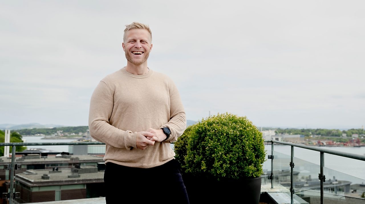 Portrett av Ørjan Ellingsen som står foran kamera og ler