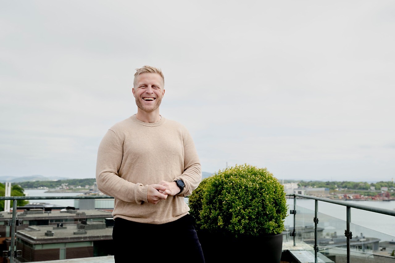 Portrett av Ørjan Ellingsen som står foran kamera og ler