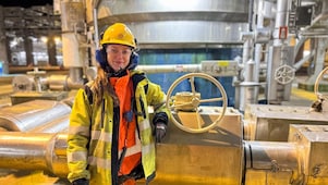 Mia står ved prosessutstyret på Nyhamna, iført Shell-kjeledress og personlig verneutstyr.