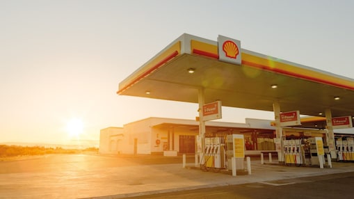 Sun rising behind a Shell station forecourt